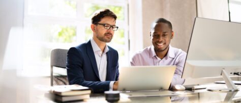 Two men conferring over a laptop about PDF Accessibility