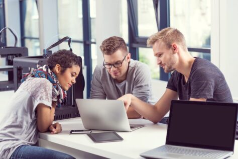 Group of disability services staff remediating inaccessible PDFs around a laptop