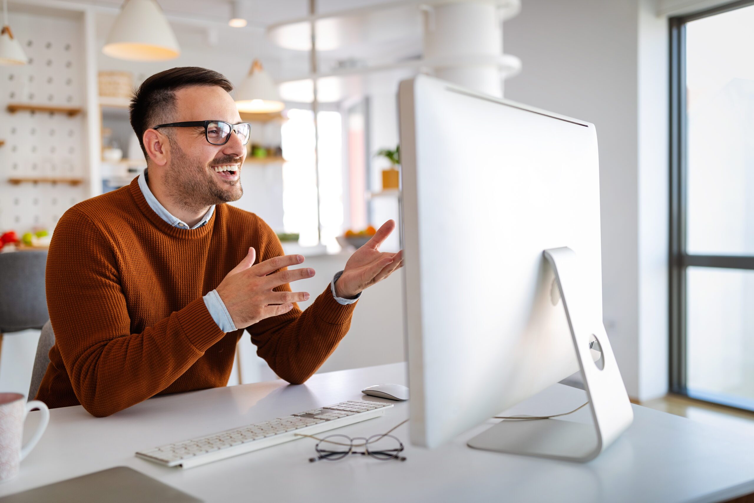 Man happily working on his computer in an office.