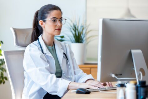 Female healthcare worker at a computer providing accessible PDFs to patients