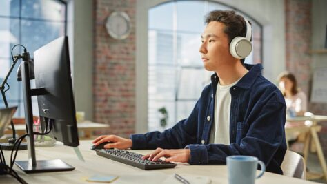 Blind man using a computer at a desk in an office
