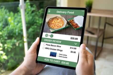 male hands hold computer tablet with food delivery