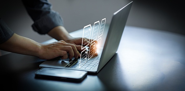 Laptop with holographic documents running Equidox Software, showing archived PDFs.