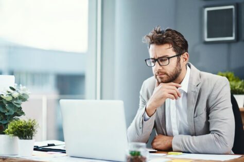 Man looking about Section 508 Compliance on his computer in an office