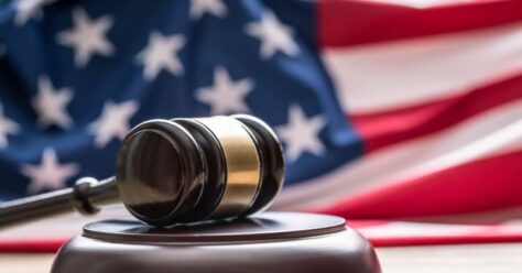 Judge's gavel in front of American flag.