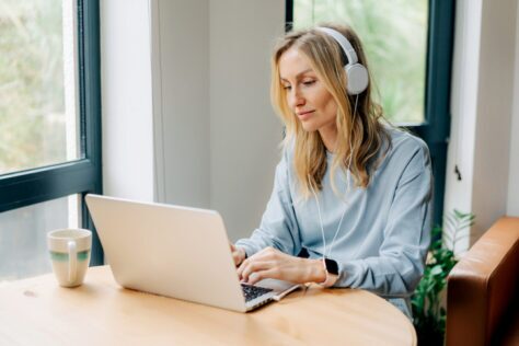 Blind woman using a laptop wearing headphones