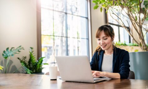 Young woman typing on a laptop in an office